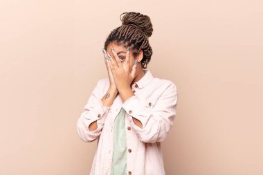 Genç afro kadın korkmuş ya da utanmış hissediyordu. Gözleri yarı kapalı ya da elleri kapalı dikizliyordu.