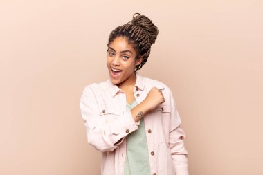 Genç afro kadın mutlu, pozitif ve başarılı hissediyor, meydan okumayla karşılaştığında motive oluyor veya iyi sonuçları kutluyor.