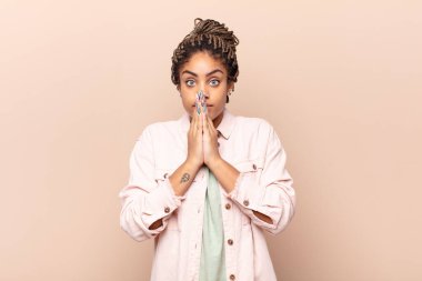 Genç afro kadın endişeli, üzgün ve korkmuş hissediyor, elleriyle ağzını kapatıyor, endişeli ve berbat görünüyor.