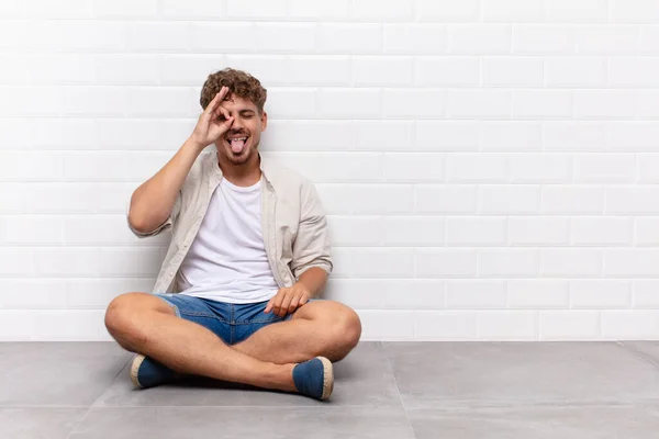 Jovem Sorrindo Feliz Com Cara Engraçada Brincando Olhando Através Espião — Fotografia de Stock