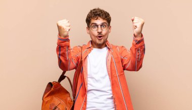 Genç adam inanılmaz bir başarıyı kutluyor kazanan gibi, heyecanlı ve mutlu görünüyor. öğrenci konsepti