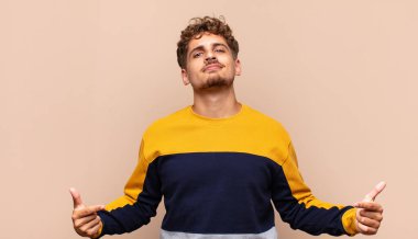 Genç adam gururlu, kibirli, mutlu, şaşırmış ve tatmin olmuş görünüyor.