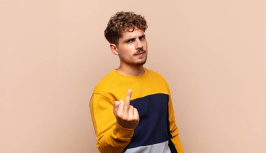 Genç adam kızgın, sinirli, asi ve agresif hissediyor, orta parmağını hareket ettiriyor, karşı koyuyor.
