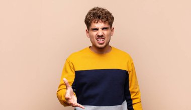 Genç adam sinirli, sinirli ve hayal kırıklığına uğramış görünüyor. Senin neyin var? 