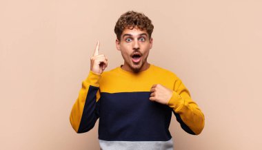 Genç adam gururlu ve şaşırmış hissediyor, kendine güvenen, başarılı bir numara gibi hisseden.