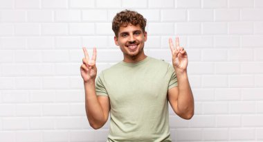 Genç adam gülümsüyor ve mutlu görünüyor, arkadaş canlısı ve tatmin olmuş, zafer ya da barış simgesi.