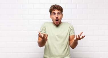 Delikanlı ağzı açık ve şaşırmış, şok olmuş ve hayretler içinde kalmış.