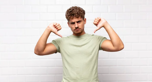 Joven Mirando Triste Decepcionado Enojado Mostrando Los Pulgares Hacia Abajo — Foto de Stock