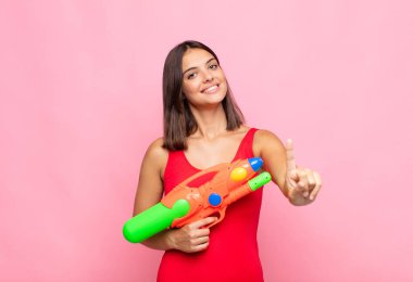 Genç ve güzel bir kadın gururla gülümsüyor ve gururla bir numaralı pozunu veriyor, bir lider gibi hissediyor. yaz konsepti