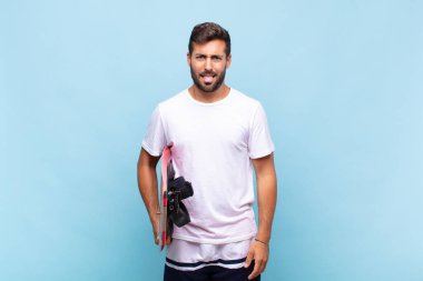 Genç adam tiksinmiş ve sinirlenmiş hissediyor, dilini dışarı çıkarıyor, iğrenç ve iğrenç bir şeyden hoşlanmıyor.