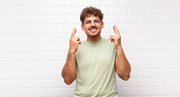 Giovane Uomo Sorridente Ansioso Incrociando Entrambe Dita Sentendosi Preoccupato Desiderando — Foto Stock