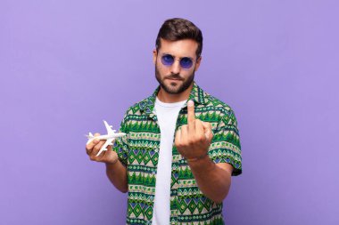 Genç adam kızgın, sinirli, isyankar ve agresif orta parmağını sallayarak karşılık veriyor. tatil kavramı