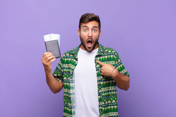 young man looking shocked and surprised with mouth wide open, pointing to self. holidays concept