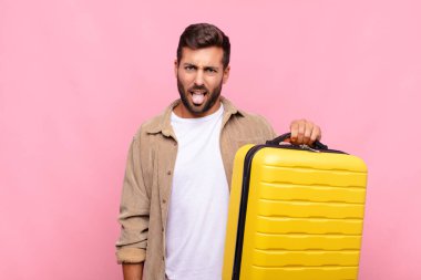 Genç adam tiksinmiş ve rahatsız olmuş hissediyor, dilini dışarı çıkarıyor, iğrenç ve iğrenç bir şeyden hoşlanmıyor. tatil kavramı