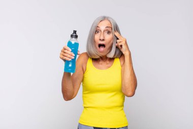 Orta yaşlı kadın şaşırmış, ağzı açık, şok olmuş, yeni bir düşünce, fikir ya da konseptin farkına varıyor. fitness konsepti