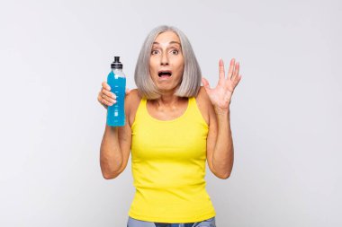 Orta yaşlı bir kadın elleri havada bağırıyor. Öfkeli, sinirli, stresli ve üzgün. fitness konsepti