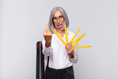 Orta yaşlı bir kadın kızgın, sinirli, isyankar ve agresif orta parmağını sallayarak karşılık veriyor. mimar konsepti