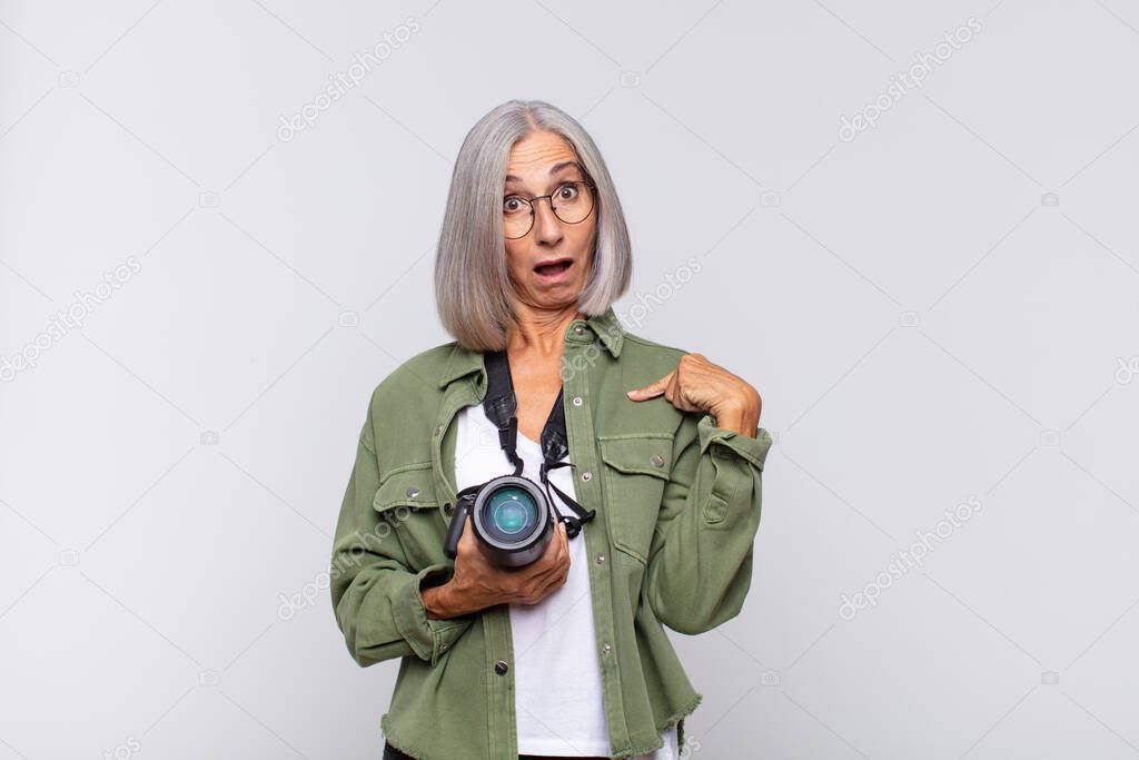 middle age woman feeling happy, surprised and proud, pointing to self with an excited, amazed look. photographer concept