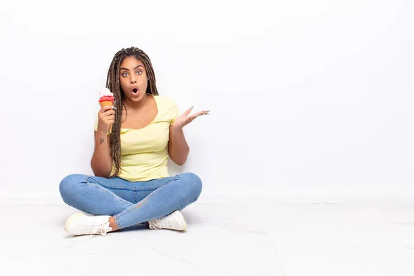 Joven Afro Mujer Mirando Sorprendida Conmocionada Con Mandíbula Caída Sosteniendo —  Fotos de Stock