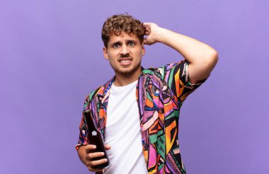 Genç adam kendini stresli, endişeli, endişeli ya da korkmuş hissediyor. Elleri başının üstünde, hata yaptığında panikliyor. tatil kavramı