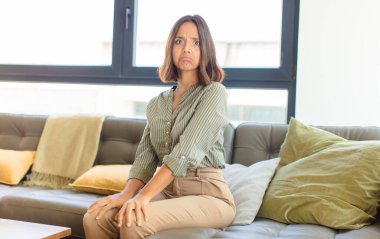 Genç Latin bir kadın üzgün ve stresli. Kötü bir sürpriz yüzünden üzgün. Olumsuz ve endişeli bir bakışla. ev kavramı