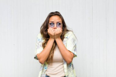 Genç, güzel bir kadın endişeli, gergin, stresli ve korkmuş görünüyor tırnaklarını yiyor ve yanal fotokopi için yer arıyor. turizm konsepti