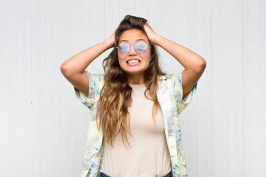 Genç, güzel bir kadın kendini stresli, endişeli, endişeli ya da korkmuş hissediyor. Elleri başının üstünde, hatayla panikliyor. turizm konsepti