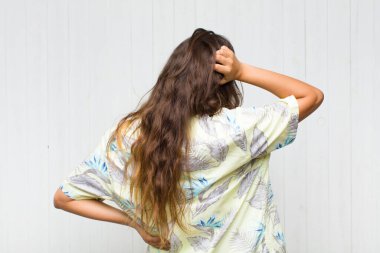 Genç, güzel bir kadın bilgisiz ve kafası karışık hissediyor, bir çözüm düşünüyor, eli kalçasında, diğeri kafasında, dikiz aynasından bakıyor. turizm konsepti