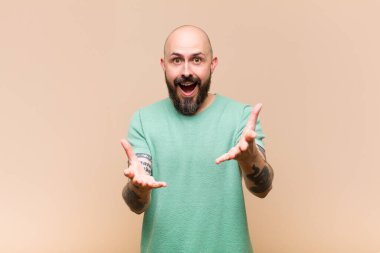 Genç kel ve sakallı bir adam kendini mutlu, şaşkın, şanslı ve şaşırmış hissediyor. İnanılmaz!