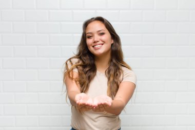 Mutlu bir şekilde gülümseyen, kendine güvenen, olumlu bakışlı, bir nesne ya da konsept sunan ve gösteren