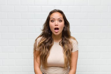 Şok olmuş ya da şaşırmış görünüyor, ağzı açık bakıyor ve 