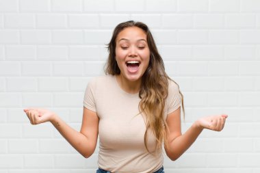 Son derece mutlu ve şaşırmış görünüyor, başarıyı kutluyor, bağırıyor ve zıplıyor.