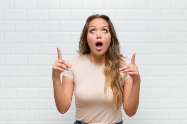 Şaşırmış, şaşırmış ve ağzı açık bir şekilde iki eliyle uzayı kopyalamak için yukarı bakıyor.