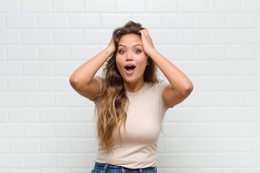 Heyecanlı ve şaşırmış görünüyor, ağzı açık, elleri başının üstünde, şanslı bir kazanan gibi hissediyor.