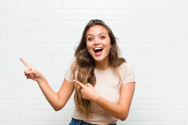 Neşeli ve şaşırmış hissediyorum, şok olmuş bir ifadeyle gülümsüyorum ve bir tarafı işaret ediyorum.