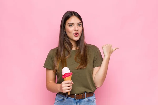 Jonge Mooie Vrouw Met Een Ijsje Kijken Verbaasd Ongeloof Wijzen — Stockfoto