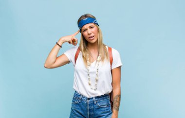 Genç, güzel hippi kadın kafası karışık ve şaşkın hissediyor. Sana deli, deli ya da aklını kaçırmış olduğunu gösteriyor.