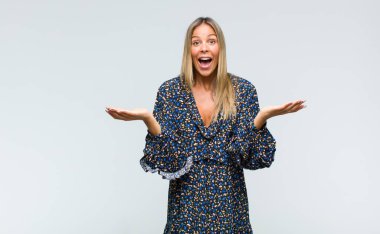 Genç, güzel bir kadın mutlu, heyecanlı, şaşırmış ya da şaşırmış hissediyor. İnanılmaz bir şeye gülümsüyor ve hayrete düşüyor.