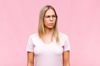 Genç, güzel bir kadın üzgün, üzgün ya da kızgın ve olumsuz bir tavır takınıyor, anlaşmazlık içinde kaşlarını çatıyor.