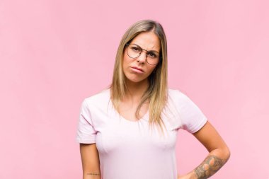 Genç ve güzel bir kadın üzgün ve mızmızlanıyor, mutsuz bir bakışla, negatif ve hayal kırıklığına uğramış bir tavırla ağlıyor.