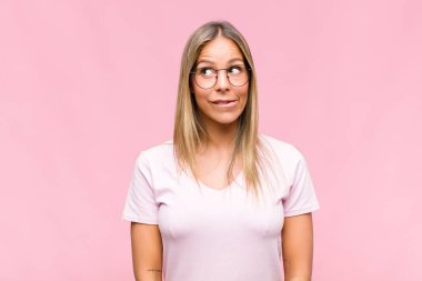 Genç, güzel bir kadın kafası karışmış ve kafası karışmış görünüyor. Sinirli bir hareketle dudağını ısırıyor. Sorunun cevabını bilmiyor.