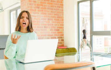 Genç, güzel bir kadın çalışıyor, kızgın, sinirli ve sinirli görünüyor. Senin neyin var? 