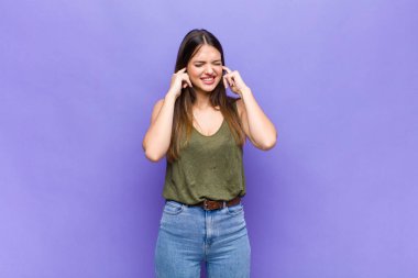 Sen güzel bir kadın kızgın, stresli ve sinirli görünüyor, iki kulağı da sağır edici bir gürültü, ses ya da yüksek sesle kapatıyor