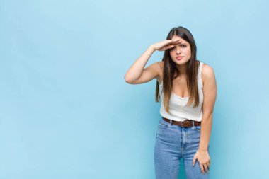 Sen güzel bir kadınsın. Şaşırmış ve şaşırmış görünüyorsun. Elin alnında uzaklara bakıyor, izliyor ya da arıyor.