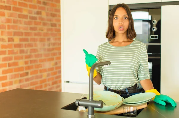 Young Pretty Woman Washing Dishes Looking Astonished Disbelief Pointing Object — Stock Photo, Image