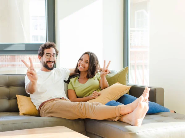 Young Couple Smiling Looking Happy Carefree Positive Gesturing Victory Peace — Stock Photo, Image