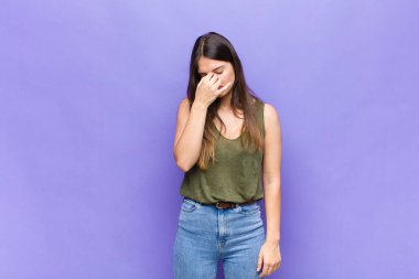 Sen güzel bir kadınsın. Stresli, mutsuz ve hayal kırıklığına uğramış, alnına dokunan ve şiddetli baş ağrısı çeken.