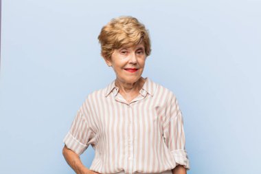 Yaşlı güzel kadın gururlu, kendine güvenen, havalı, küstah ve küstah görünüyor, gülümsüyor, başarılı hissediyor.