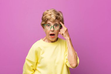 Yaşlı güzel kadın şaşırmış, ağzı açık, şok olmuş, yeni bir düşünce, fikir ya da konsept keşfediyor.