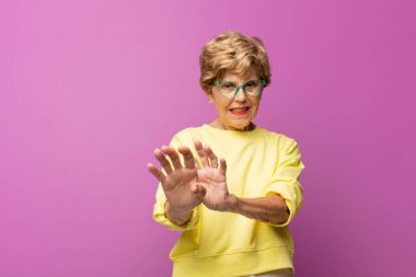 Yaşlı güzel kadın tiksiniyor ve midesi bulanıyor. İğrenç, kokuşmuş ya da kötü kokan bir şeyden kaçıyor.